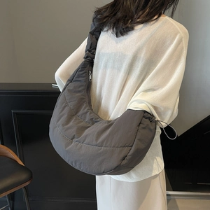 Deep grey quilted crescent crossbody bag with minimalist nylon finish and metal zipper