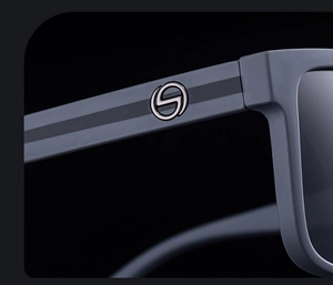 Detail of matte grey square frame sunglasses with metal S-logo on wide temple
