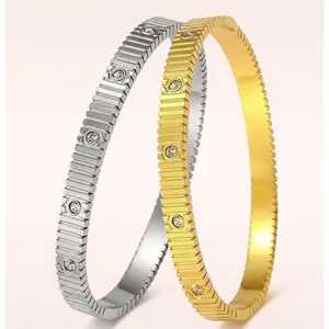 Polished stainless steel bracelets with vertical grooves and inlaid crystals in gold and silver