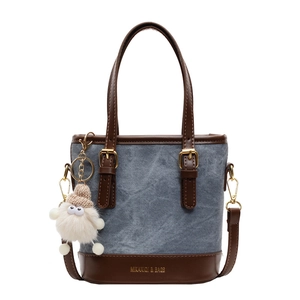 Sac seau en denim bleu et cuir marron avec breloque en peluche et boucles métalliques