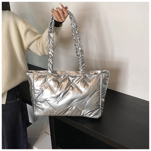 Detail view of silver quilted tote bag featuring rhinestone trim and ruched handles