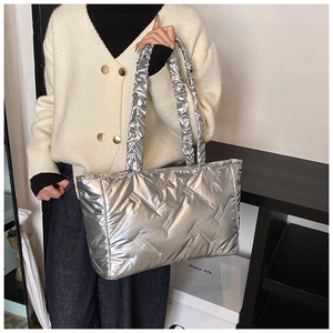 Detail of silver quilted tote bag with unique ruched handles and metallic finish