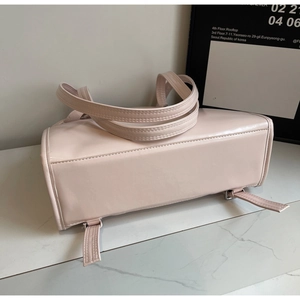 Detail of light pink faux leather tote bag base construction and smooth texture finish