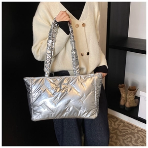 Detail view of silver quilted tote bag featuring stylish ruched cloud shoulder strap