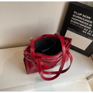 Detail of red patent leather tote bag with spacious interior compartments and zip pocket