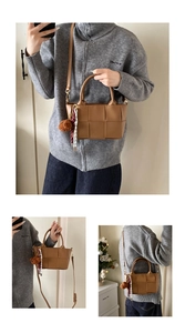 Détail du sac seau marron tressé avec texture en similicuir et pendentif d'ours