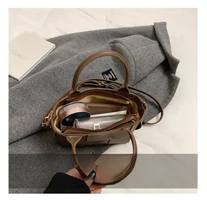 Vue intérieure du sac à bandoulière tressé marron montrant sa grande capacité pour les essentiels