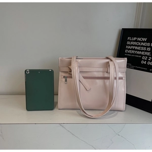 Macro view of polished light pink tote bag with sleek shoulder straps and zip detail
