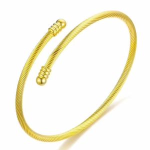 Detail view of a gold-plated twisted cable bracelet with decorative spherical ends