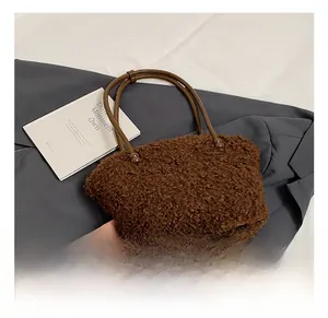 Gros plan du sac cabas en peluche marron avec fines anses rondes en cuir