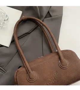 Detail of dark brown leather bowling bag showing white stitching and shoulder strap