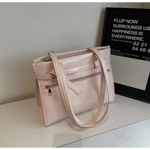 Detail of light pink patent leather tote bag with shoulder strap and zipper pocket