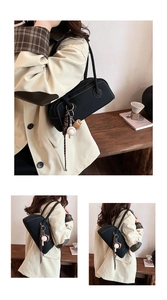 Detail of black bowling bag with white stitching and stylish baseball-themed charm