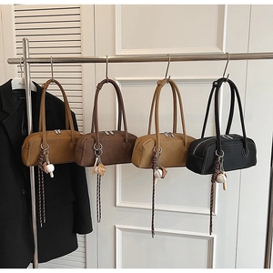 Detail of four matte leather bowling bags with contrast stitching and baseball charms