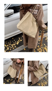 Detailansicht der beigen Krokodilprägung und der langen Trageriemen dieser großen Tote-Bag