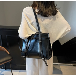 Minimalist black patent leather tote bag shown on model to display size and fit