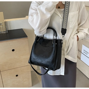 Détail du sac cabas noir avec bandoulière géométrique et anse d'épaule en cuir
