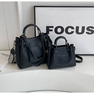 Détail d'un ensemble de sacs noirs avec poignées en métal et bandoulière tissée
