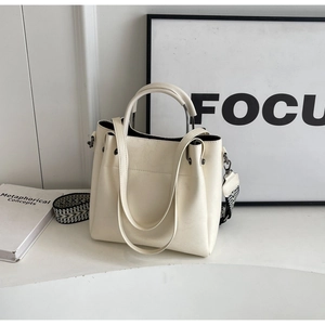 Détail du sac fourre-tout blanc crème avec finition texturée et bandoulière tissée chic