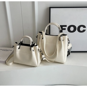 Détail du lot de sacs fourre-tout crème avec poignées en métal et bandoulière tissée