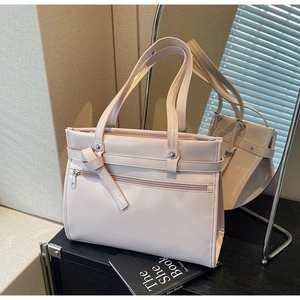 Detail of light pink PU leather tote with front zipper and knotted strap design