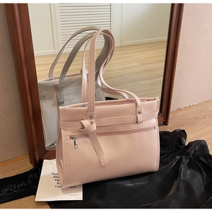 Close-up of pink PU leather tote bag featuring knot detail and zipper pocket decoration