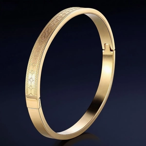 Polished gold titanium steel bangle featuring creative geometric engraving and side hinge