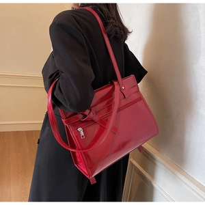 Red glossy patent leather tote bag with double straps and zipper pocket details