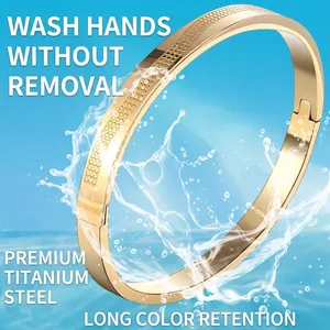 Polished gold titanium steel cuff bracelet with heart pattern and water splash background