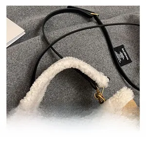 Detail of winter suede bucket bag featuring white faux fur handle and leather strap