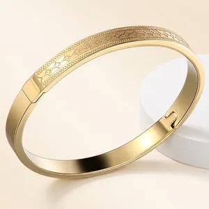 Minimalist gold titanium steel bangle with geometric engraved texture and side clasp