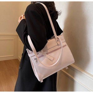 Pink leather tote bag with long straps and front zipper pocket on a black blazer
