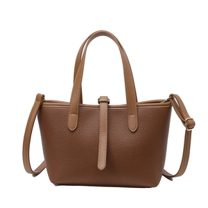 Brown lychee leather bucket tote bag with dual handles and adjustable shoulder strap