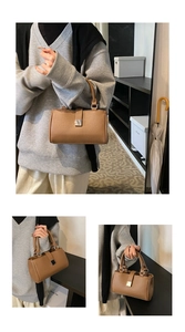 Detailed macro view of the brown lychee grain texture and silver metal buckle on the handbag