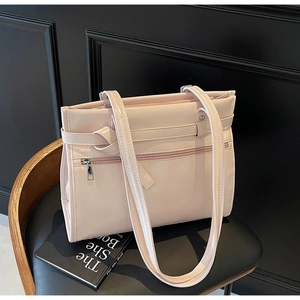 Detail of the light pink patent leather texture and metallic shine on a modern tote bag