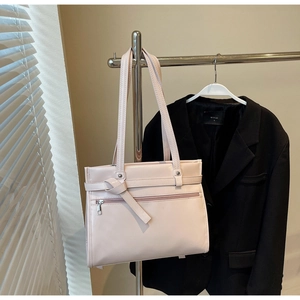 Detail of light pink tote bag with leather knot straps and horizontal zipper pocket