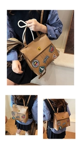 Dettaglio della borsa vintage marrone con toppe ricamate e chiusura a girello dorata