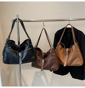 Détail de grands sacs fourre-tout en noir, caramel et marron avec ferrures argentées