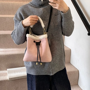 Pink suede bucket bag with white fleece trim and drawstring closure for women