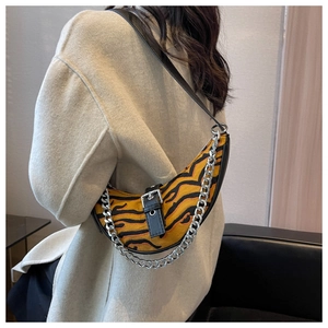 Détail du sac demi-lune imprimé tigre avec chaîne argentée et boucle en cuir noir