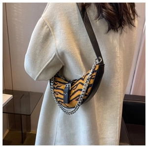 Détail du sac demi-lune motif tigre avec chaîne argentée et bandoulière en cuir noir