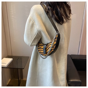Détail du sac croissant imprimé tigre avec bordure en cuir et chaîne argentée