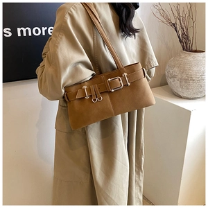 Detail of retro shoulder bag featuring textured leather and metal buckle with belt strap