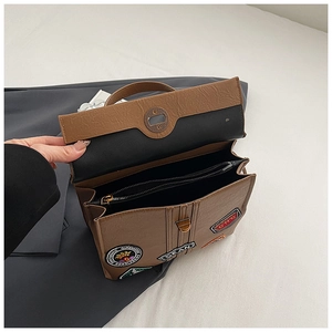 Dettaglio borsa vintage marrone con scomparti interni e decorazioni ricamate