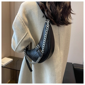 Détail du sac bandoulière noir à motif crocodile avec chaîne en métal argenté
