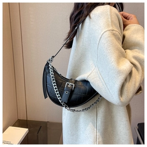 Détail du sac demi-lune en cuir crocodile noir avec chaîne argentée et boucle métal
