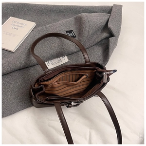 Deep brown matte leather tote bag interior showing striped fabric lining and side pocket