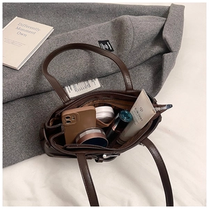 Detailed view of dark brown biker bag interior with ample space for makeup and phone