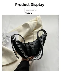 Close-up of black crocodile-embossed dumpling bag with silver chain and metal buckle