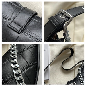 Detailed views of black crocodile texture leather with silver chain and metal hardware